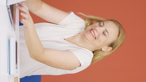 Vertical-video-of-Woman-looking-at-laptop-is-happy-and-dancing.